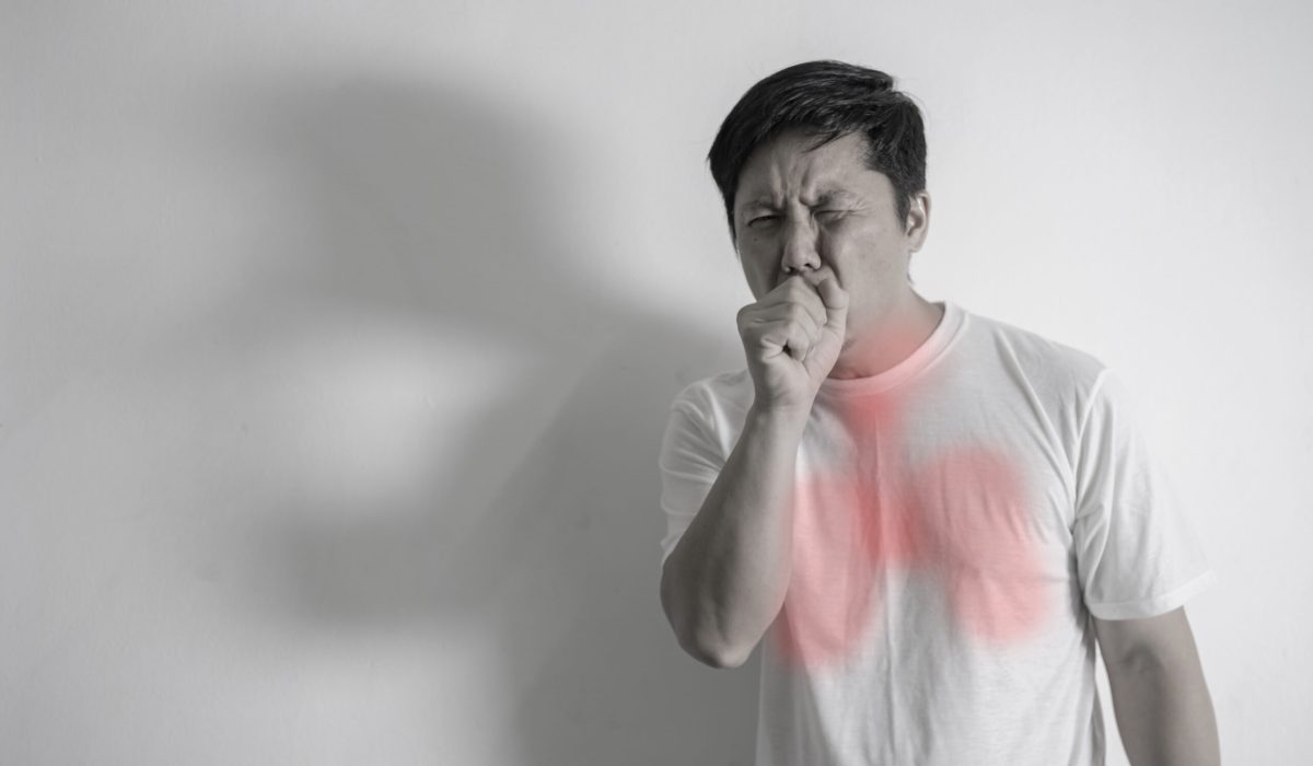 Sick man coughing concept. Handsome man coughing into his fist, isolated on a white background. A man about forty years old had a strong cough.